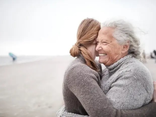 A mother and daughter embracing on the beach