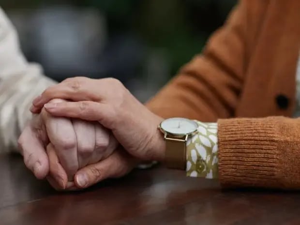 Two people holding hands intimately