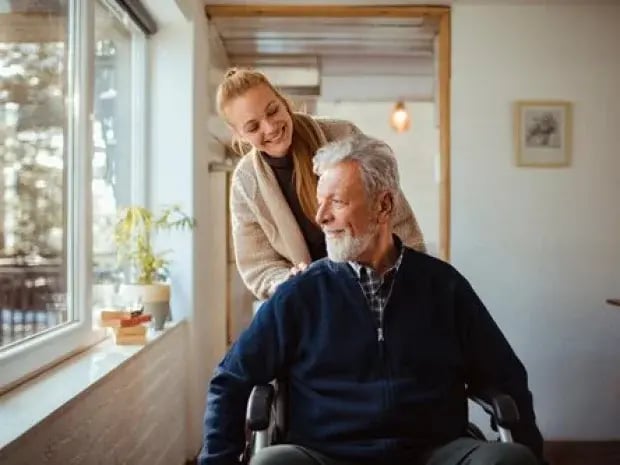 A daughter pushing her father in a wheelchair