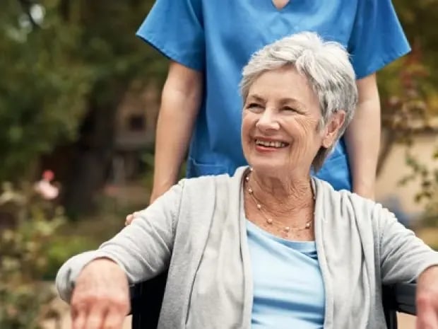 Elderly woman in wheelchair enjoying her time outside