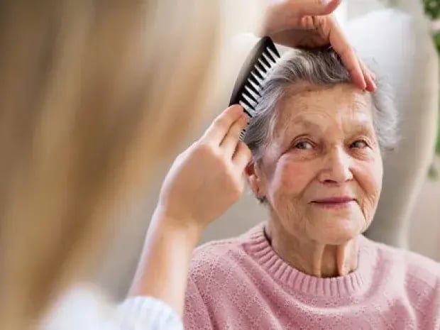 Elderly woman having her hair brushed Elderly woman having her hair brushed
