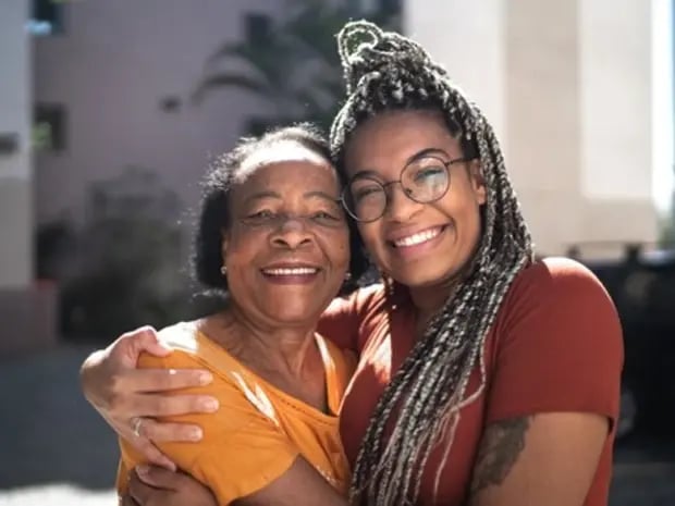 Grandmother and granddaughter smiling and embracing